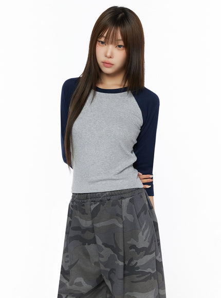Two-Tone Long Sleeve Top IL523 grey and navy front shot on model hands on hip paired with grey camo wide-leg sweatpants, fitted body