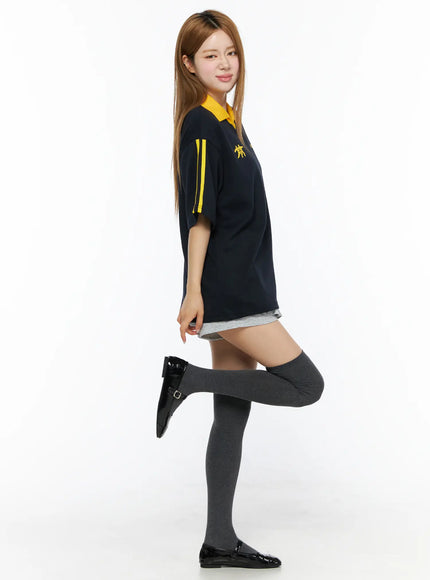 Two-Tone Relaxed-Fit Polo Shirt CL502 Dark blue side shot on model one leg raised showing yellow double sleeve stripe detail and relaxed silhouette with knee-high socks