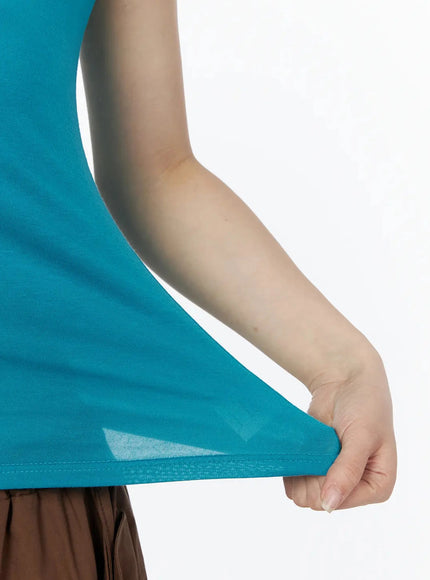 Two-Way Layered Cami Top IU525 Blue close-up detail shot of hemline showing model stretching fabric to display lightweight sheer texture and stitching
