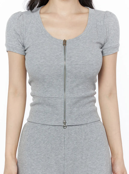 Two-Way Top & Sweatpants Set IU525 Gray close-up front shot on model holding tumbler and pink bag, showing two-way zip and puff sleeve ribbed top