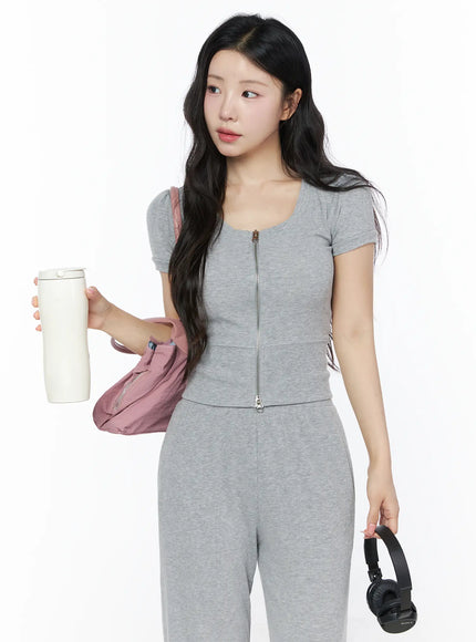 Two-Way Top & Sweatpants Set IU525 Gray upper-body front shot on model holding tumbler and headphones with pink bag, lifestyle styling