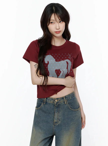 Unicorn Graphic Crop T-Shirt IL506 Dark red front model shot arms crossed showing large grey horse graphic with blue stars crop hemline styled with jeans