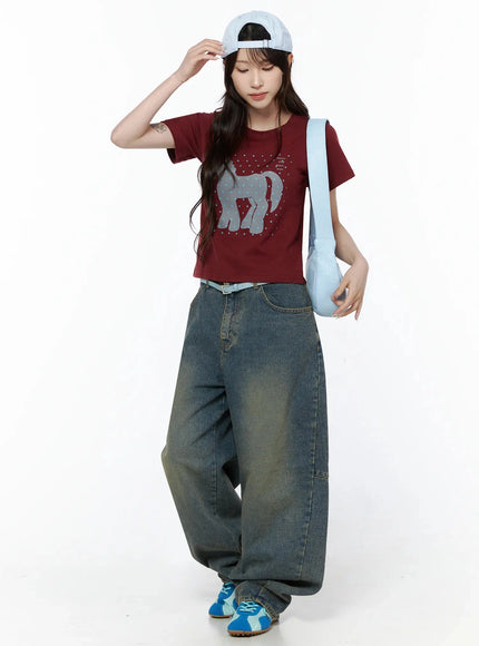 Unicorn Graphic Crop T-Shirt IL506 Dark red full-body model shot looking down styled with light blue cap crossbody bag wide-leg jeans and blue sneakers