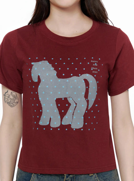 Unicorn Graphic Crop T-Shirt IL506 Dark red close-up front detail shot showing grey horse silhouette star print and Happy New Year 2026 text on cotton fabric
