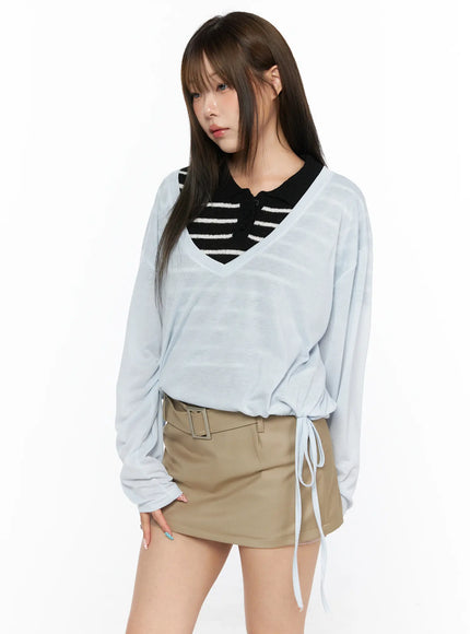 V-Neck Loose Drawstring Long Sleeve Top CL514 light blue angled front view model slight turn showing V-neck sheer long sleeve top with drawstring hem and khaki mini skirt