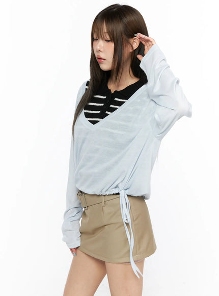 V-Neck Loose Drawstring Long Sleeve Top CL514 light blue angled front view model hand in hair showing V-neck and drawstring hem with striped inner top visible