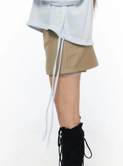 V-Neck Loose Drawstring Long Sleeve Top CL514 light blue close-up detail of side drawstring ties at hem showing sheer texture and khaki mini skirt underneath