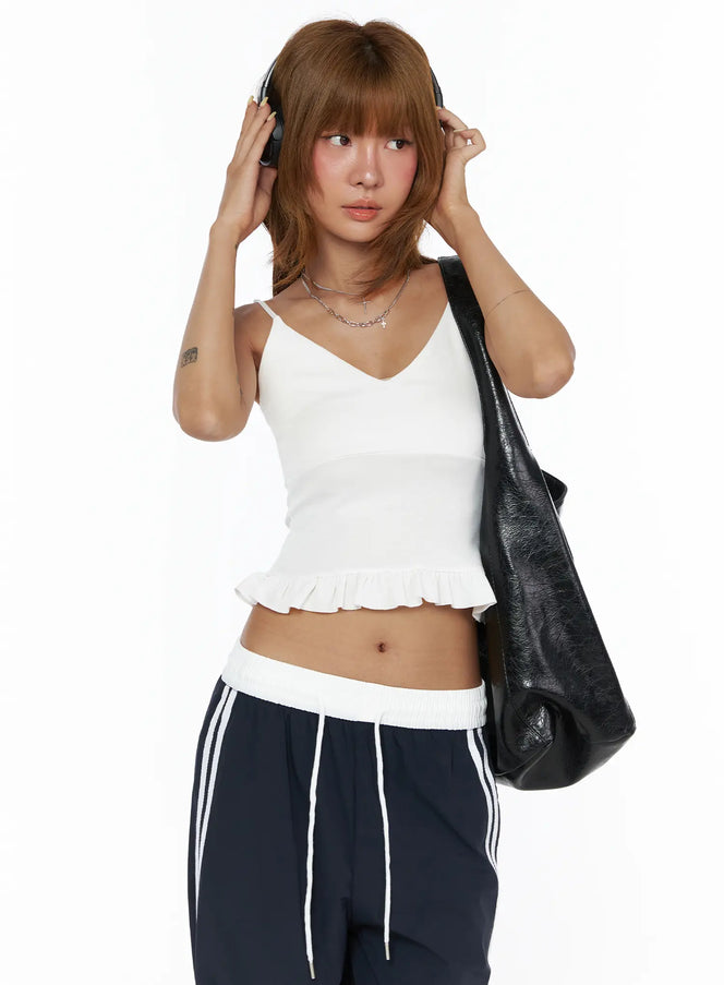 LEWKIN V-Neck Ruffle Cami Top CL503 White S/M front shot on model wearing headphones and black bag, fitted ribbed crop with ruffle hem