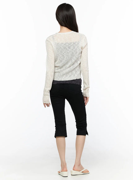 V-Neck Sheer Cardigan CL522 light beige back shot on model, semi-sheer ribbed knit showing through texture, cropped length with lace-trim underlayer, black capri pants