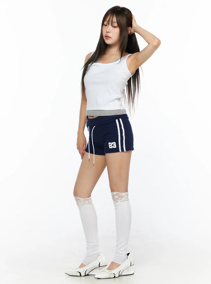 Varsity Athletic Shorts CL514 Dark blue three-quarter front shot on model hand raised to head showing number 23 emblem white stripes athletic mini length