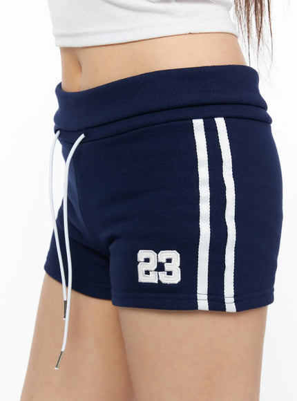 Varsity Athletic Shorts CL514 Dark blue close-up side detail shot showing embroidered number 23 double white ribbed stripes fold-over waistband and drawstring