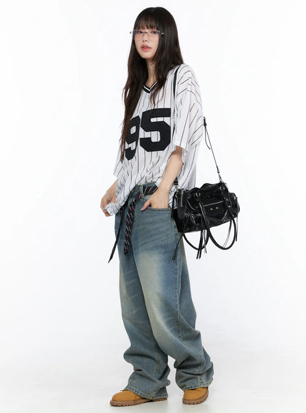 Vexi Washed Baggy Jeans CL523 Blue full-body side view on model in striped number-95 jersey and glasses, hand in pocket, showing oversized wide-leg drape and faded wash