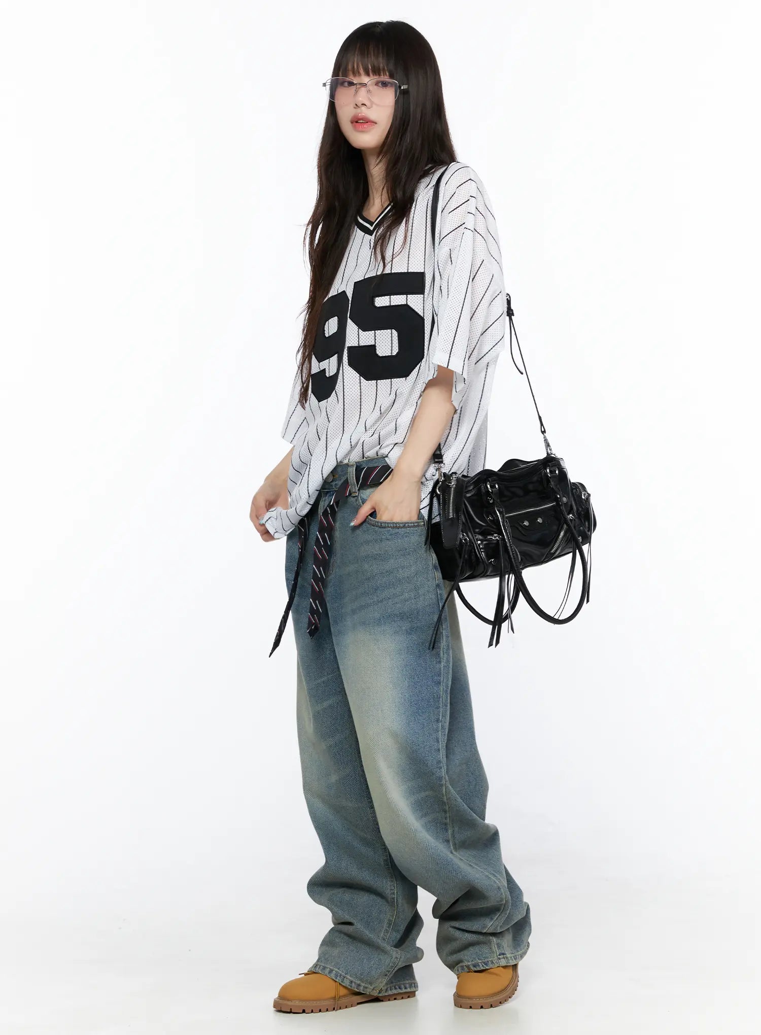 Vexi Washed Baggy Jeans CL523 Blue full-body side view on model in striped number-95 jersey and glasses, hand in pocket, showing oversized wide-leg drape and faded wash