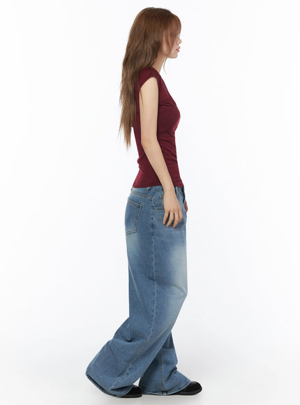 Veya Washed Baggy Jeans IU525 Blue side profile full-length shot on model, showing extreme wide-leg volume and faded wash texture, styled with burgundy sleeveless top