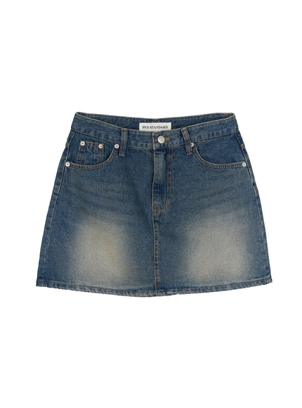 Vintage A-Line Denim Mini Skirt IL506 Blue flat-lay front view showing BYD STANDARD label, silver button closure, five-pocket design, and A-line shape with vintage wash
