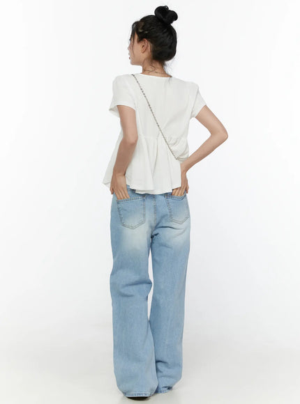 Wade Light Washed Wide Leg Jeans CL520 Light blue full back shot on model styled with white peplum top and chain crossbody bag showing back pockets and wide leg silhouette