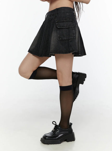 Washed Denim Mini Skirt CL508 Black side detail shot on lower body model with leg lifted showing pleated flare cargo pocket and raw hem