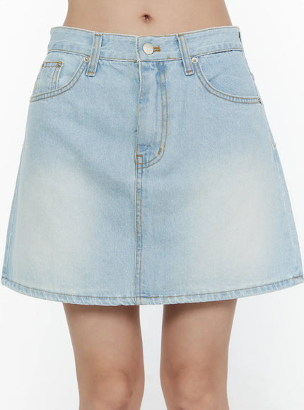 Washed Denim Skirt CL521 Light blue close-up front detail shot on model showing waistband button fly front pockets and faded denim texture