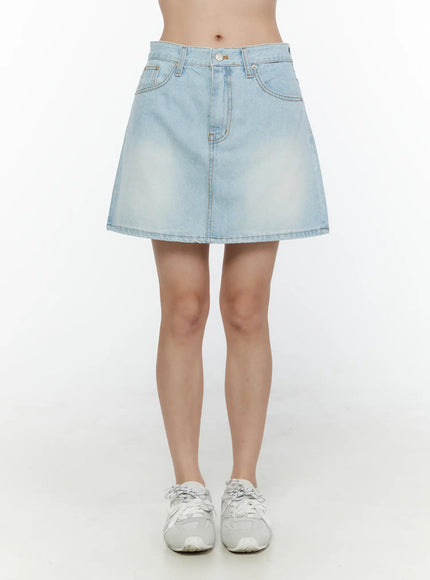 Washed Denim Skirt CL521 Light blue front model shot wider framing showing full A-line mini skirt silhouette faded wash front pockets and white sneakers