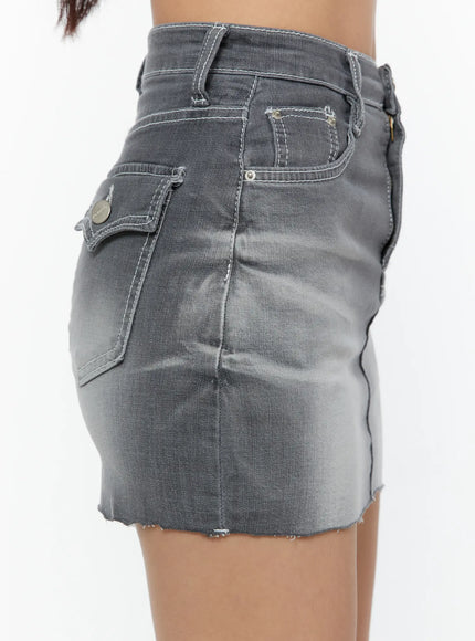 Washed Mid-Rise Denim Mini Skirt CU529 Gray close-up side shot on model highlighting back flap pocket with metal logo button, side seam, and raw cutoff hem detail