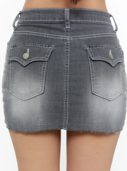Washed Mid-Rise Denim Mini Skirt CU529 Gray close-up back shot on model showing dual decorative flap pockets, white topstitching, faded wash, and frayed raw hem