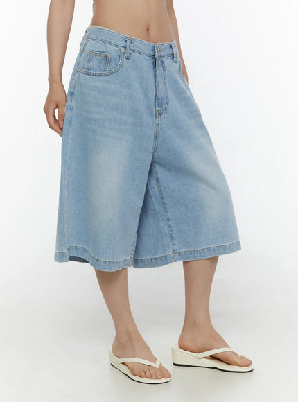 Washed Wide Leg Jorts CL508 Blue side view on model showing wide flared leg shape, faded wash, front pocket, and hem stitching with white wedge sandals