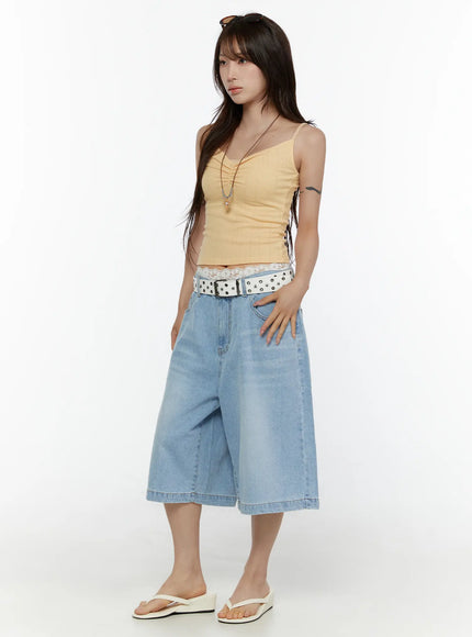 Washed Wide Leg Jorts CL508 Blue three-quarter side view on model styled with yellow cami, white star belt, and white wedge sandals, hand in pocket pose