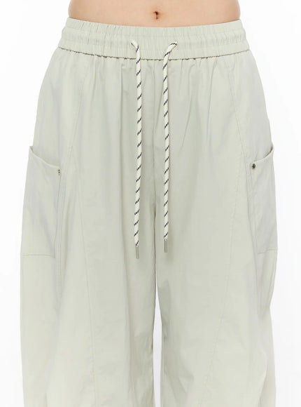 Wide Leg Cargo Pants CL501 Light beige close-up front detail shot showing elastic smocked waistband, braided rope drawstring with metal aglets and side zip pocket