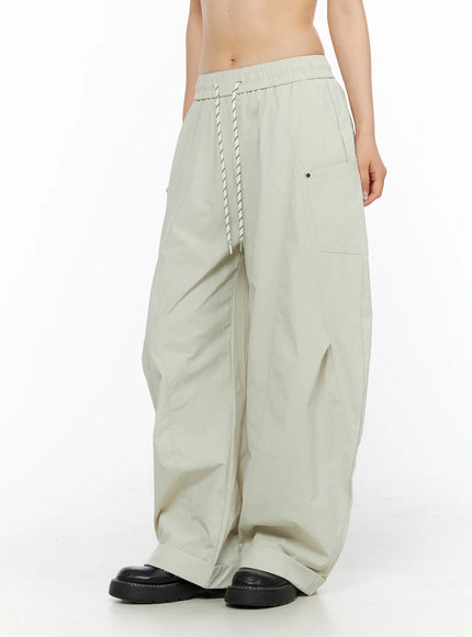 Wide Leg Cargo Pants CL501 Light beige three-quarter side shot on model showing wide parachute leg silhouette, side cargo pocket and rolled cuff hem
