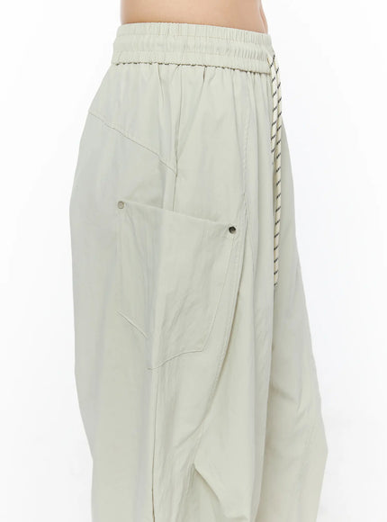 Wide Leg Cargo Pants CL501 Light beige close-up side detail shot showing large cargo pocket with double snap buttons, elastic waistband and hanging rope drawstring
