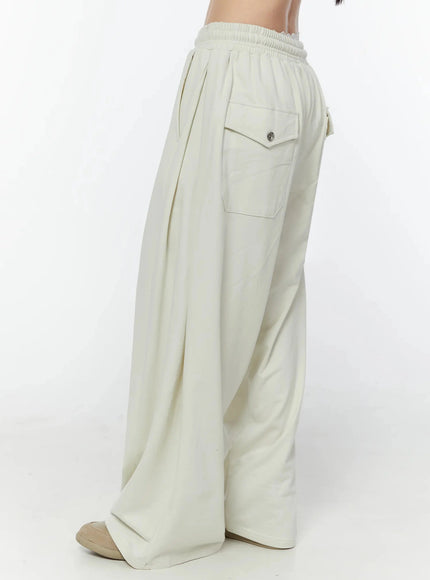 Wide Leg Sweatpants IU524 Light beige rear three-quarter view on model showing single back flap cargo pocket with silver snap button detail