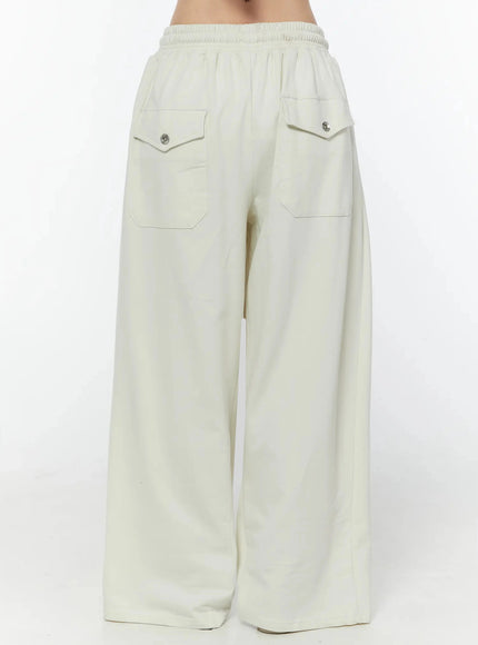 Wide Leg Sweatpants IU524 Light beige back view no model showing two patch pockets with pointed flaps and silver snap buttons on elastic waistband