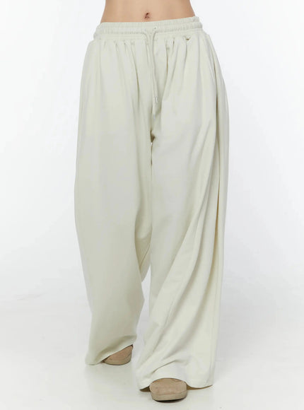 Wide Leg Sweatpants IU524 Light beige front view on model, waist-to-hem shot showing smocked elastic waistband, drawstring and draped wide-leg fabric