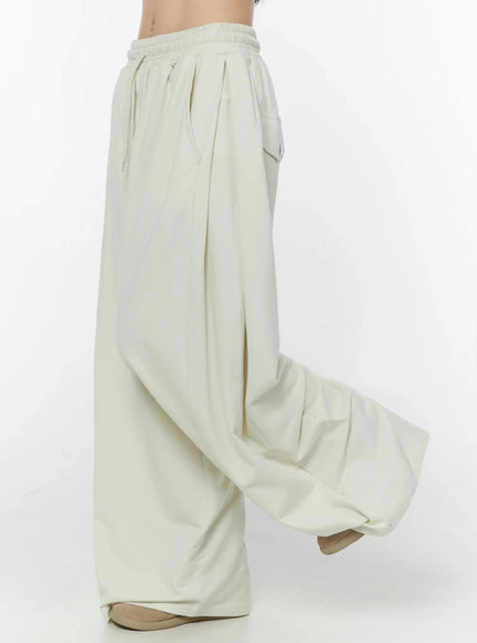 Wide Leg Sweatpants IU524 Light beige side view on model showing deep side pocket flap and voluminous wide-leg hem pooling at floor