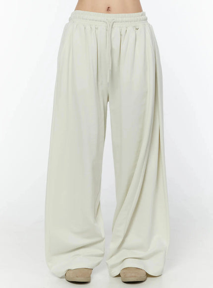 LEWKIN Wide Leg Sweatpants IU524 Light beige front view on model, cropped waist shot showing elastic drawstring waistband and wide-leg silhouette