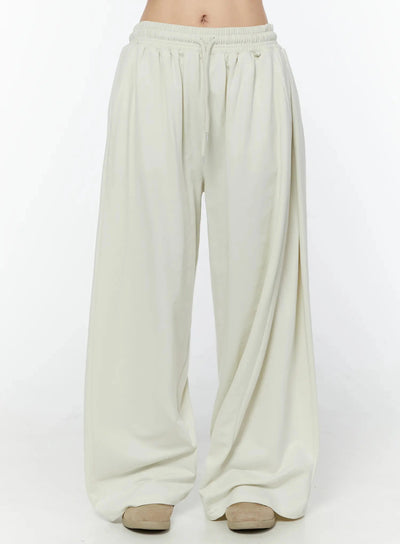 LEWKIN Wide Leg Sweatpants IU524 Light beige front view on model, cropped waist shot showing elastic drawstring waistband and wide-leg silhouette