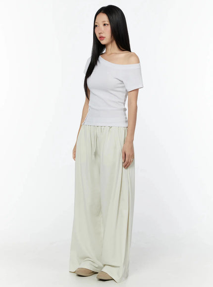 Wide Leg Sweatpants IU524 Light beige three-quarter front view on model styled with white off-shoulder tee, showing drawstring waist and flowy wide-leg drape