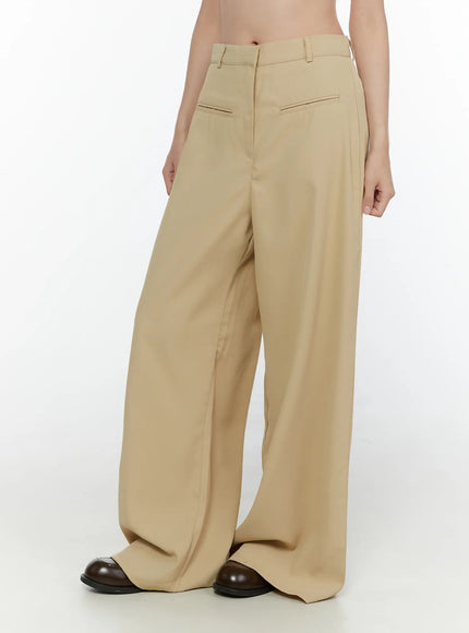 Wide Leg Tailored Pants CL520 Beige side-back view on model showing diagonal seam line high rise waistband and voluminous wide leg hem with brown loafers