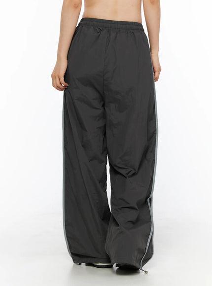 Wide Leg Track Pants CL501 Dark gray back view on model showing elastic waistband, reflective gray side stripe, voluminous wide-leg nylon