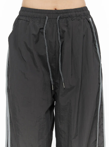Wide Leg Track Pants CL501 Dark gray close-up detail of drawstring elastic waistband, side seam reflective stripe, crinkled nylon texture