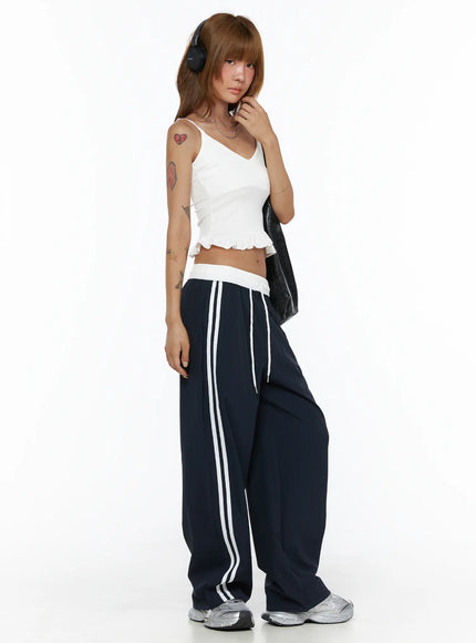 LEWKIN Wide Leg Track Pants CL503 Dark blue side shot on model wearing headphones, wide-leg silhouette with white side stripes and white elastic waistband, S/M