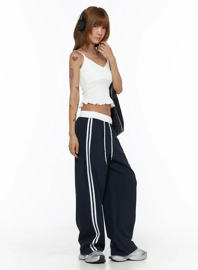 LEWKIN Wide Leg Track Pants CL503 Dark blue side shot on model wearing headphones, wide-leg silhouette with white side stripes and white elastic waistband, S/M