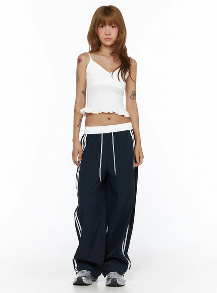 Wide Leg Track Pants CL503 Dark blue front full-length shot on model standing, white side stripe detail, white elastic waistband with drawstring, styled with white crop top