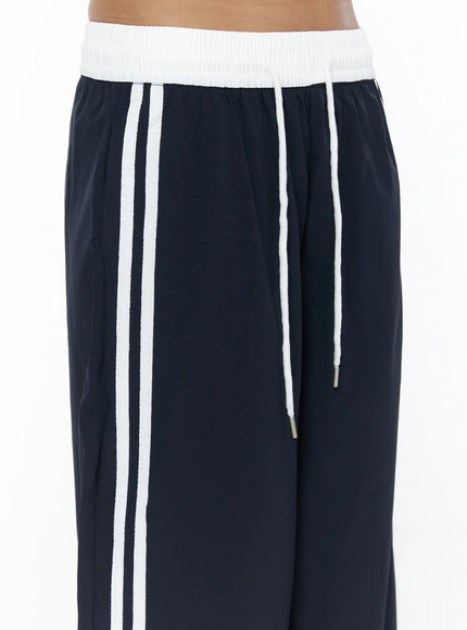 Wide Leg Track Pants CL503 Dark blue close-up detail of white ribbed elastic waistband, double white side stripes, and drawstring with metal aglet tips