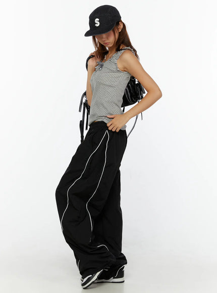 LEWKIN Wide-Leg Track Pants CL515 Black M/L front shot on model styled with gray tank top and black cap, wide nylon pants with white piping