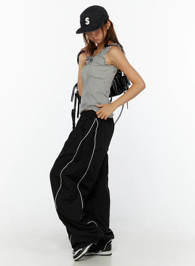 LEWKIN Wide-Leg Track Pants CL515 Black M/L front shot on model styled with gray tank top and black cap, wide nylon pants with white piping