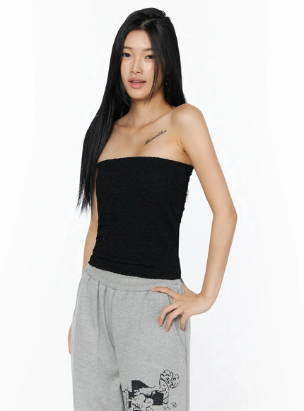 Wrinkle Textured Tube Top IL516 Black front shot on model looking away, arms crossed, showcasing textured tube silhouette with grey sweatpants