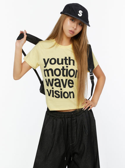 LEWKIN Youth Graphic Short Sleeve Tee IL524 Yellow front view on model wearing black cap and backpack, styled with wide-leg dark pants, S/M