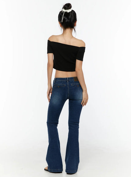 Zainab Low-Rise Flared Bootcut Jeans CU529 Dark blue back full-body shot on model in black off-shoulder top showing rear pockets, logo patch and flared leg