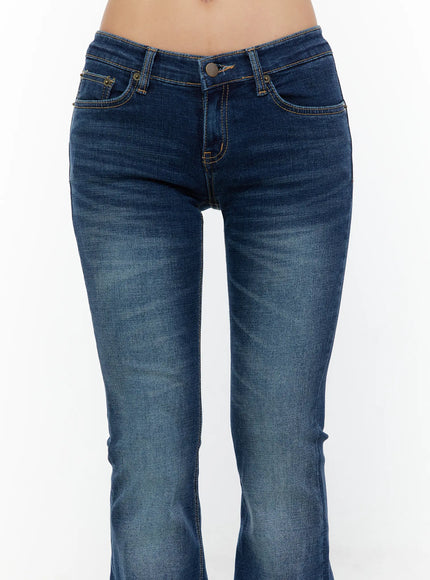 Zainab Low-Rise Flared Bootcut Jeans CU529 Dark blue close-up front shot on model highlighting low-rise waistband, gold-tone button, contrast stitching and pocket detail